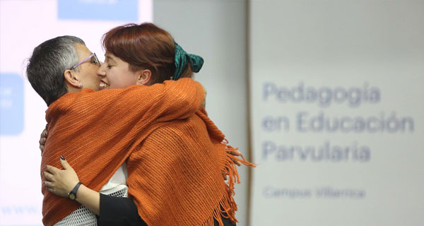 Un par de académicos se abrazan en una Ceremonia de Formación de Profesores