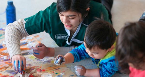 Alumna de Pedagogía en Educación Parvularia pintando con niños