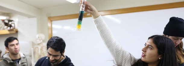 Alumna sosteniendo tubo de ensayo en un laboratorio