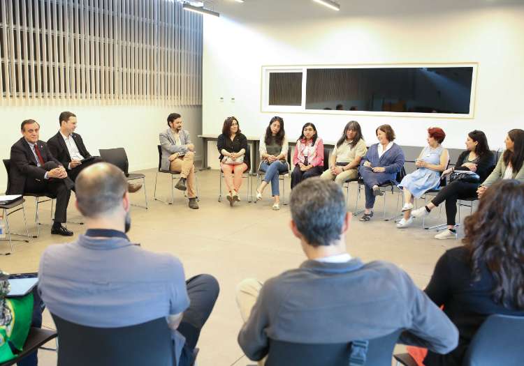 Un grupo de académicos y administrativos en una reunión circular en el auditorio del CIDS durante la visita del rector al Campus Villarrica.